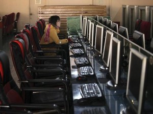 A woman uses a computer in an internet cafe in Shanghai