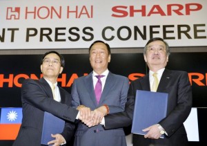 Founder and Chairman of Taiwan's Foxconn shakes hand with the company Vice Chairman and Japan's Sharp Corp Chief Executive at their joint news conference in Sakai